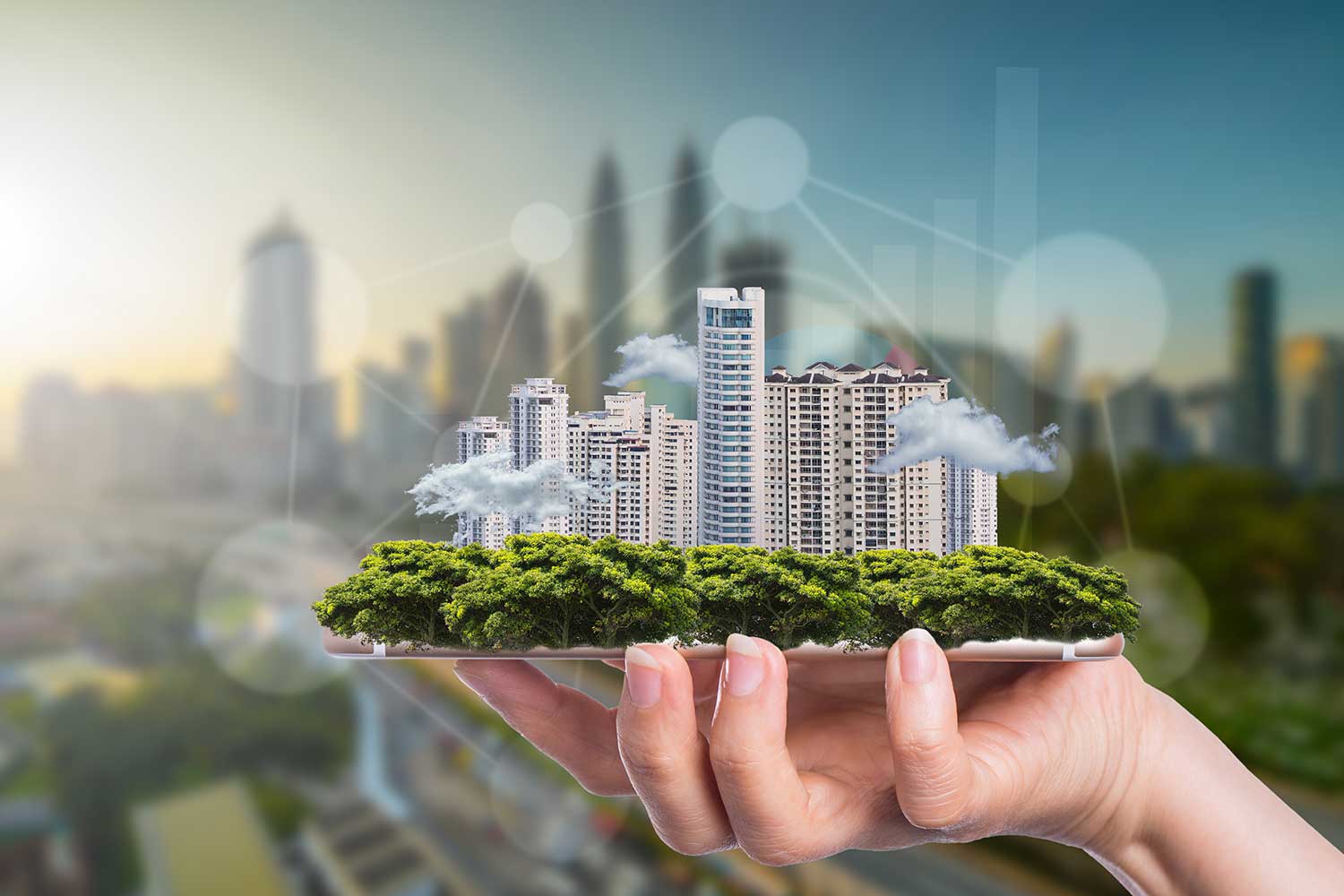 Hand hält Gebäudekomplex, welcher symbolisch für Smart Buildings steht.