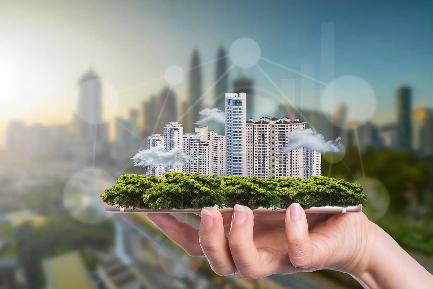 Hand hält Gebäudekomplex, welcher symbolisch für Smart Buildings steht.